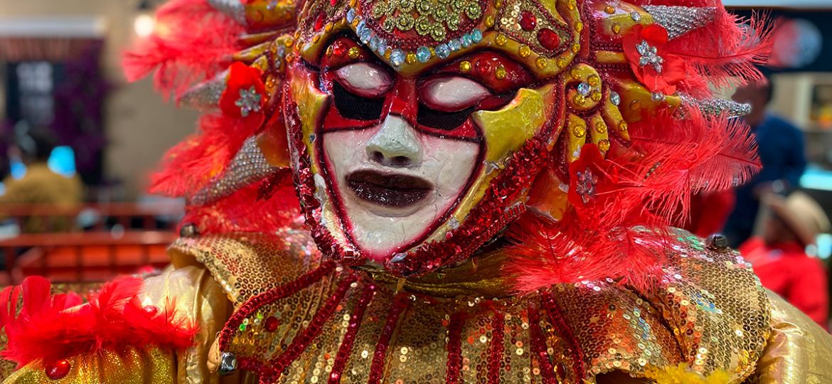 hombre disfrazado con mascara de carnaval blanca dorada y roja